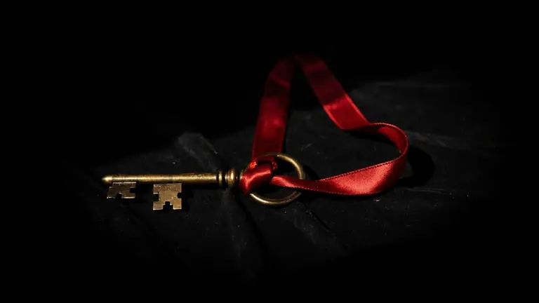An antique key tied with a red silk ribbon